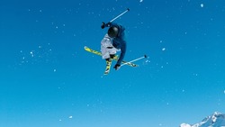 Freestyle skier takes off the kicker and does a difficult high flying 360 grab. Young male tourist on skiing trip rides around the fun park and does breathtaking tricks. Athletic traveler skiing.
