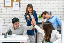 Group Of Asian Business people celebrating and giving high five together with happiness action and in the modern Office, Project succeed and teamwork successful, people business group concept