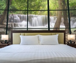 Luxury Interior bedroom with windows glass beside Beautiful waterfall in the deep forest, relax and holiday concept, 
