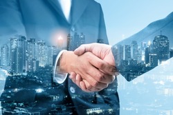 Double exposure of business handshake for successful of investment deal and city night background, teamwork and partnership concept, blue tone.