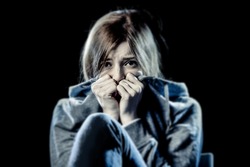 lonely young teenager girl in stress and pain suffering depression looking sad and scared with fear face expression isolated on black background victim of abuse or in mental condition