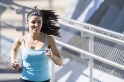 close up face of young beautiful and athletic sport woman running and jogging in urban training workout crossing modern metal city bridge in female runner body care and healthy lifestyle concept 