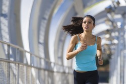 young beautiful and athletic sport woman running and jogging in urban training workout crossing modern metal city bridge in female runner body care and healthy lifestyle concept 