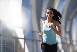 young beautiful and athletic sport woman running and jogging in urban training workout crossing modern metal city bridge in female runner body care and healthy lifestyle concept with lens flare 