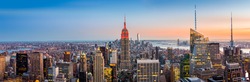 Aerial view over New York City at sunset. The Empire State Building is colored in red to honor the New York City Fire Department (FDNY)
