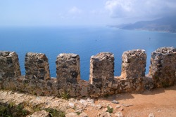 Fragment of the fortress wall overlooking the sea. These are the so-called teeth of the fortress wall. Fortress of Alanya in Turkey.