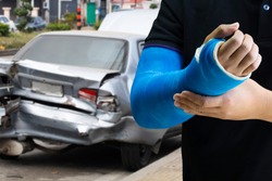 Close up man holding hand with blue bandage as arm injury concept with car accident.