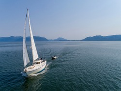 USA, Alaska, Tongass National Forest, Aerial view of Gulf 32 sailboat S/V Abuelos sailing through Frederick Sound on summer afternoon