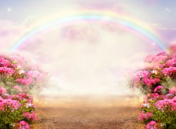 Fantasy panoramic photo background with pink rose garden, misty path leading to fabulous rainbow unicorn house. Idyllic tranquil morning scene and empty copy space. Road goes across hills to fairytale