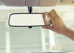 Hand adjusting rear view mirror.