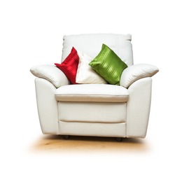 White armchair with colorful pillows isolated on white background. Object with clipping path