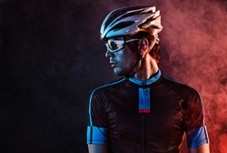 Sport background with copyspace. Cyclist. Dramatic colorful close-up portrait.