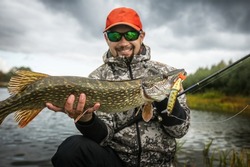 Fisherman and trophy Pike. Fishing background.