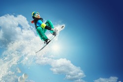 Snowboarder jumping against blue sky 