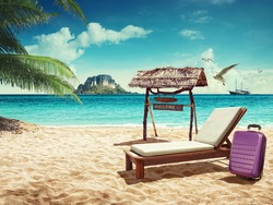Travel. Beach chair and suitcase on sand beach. Concept for rest