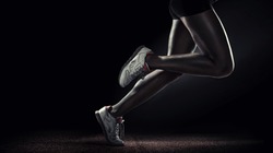 Sports background. Runner. Side view of a jogger legs isolated on black