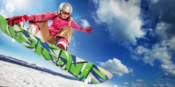 Sports background. Snowboarder jumping through air with deep blue sky in background.
