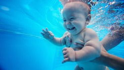 Baby background. Happy infant learn to swim, dive underwater with fun in pool to keep fit. Diving.