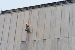 Construction worker and grey cement wall.