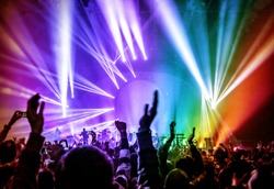 Happy young people having fun on rock concert in nightclub, colorful glowing lights, enjoying popular music, partying concept