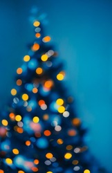 Festive Xmas Background. Bright Glowing Blur Christmas Tree Bokeh Lights. Traditional Decor for Winter Holidays. Abstract Cozy Winter.