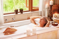 Woman relaxing at spa resort, lying down in the bath with closed eyes and make a compress, pleasure and healthy lifestyle 