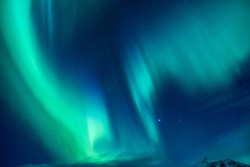 Beautiful blue and green Northern light, abstract natural background, magic paranormal light in the night starry sky, beautiful nature of Iceland