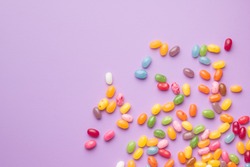 Sweet jelly beans on colorful background.