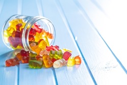 Jelly gummy bears candy. Colorful sweet confectionery on blue table.