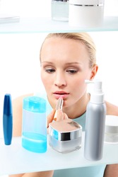 Shopping frenzy - a woman in a cosmetic shop.  A woman stands at the client shelf and selects cosmetics 