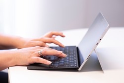 closeup of woman working and typing on a tablet PC