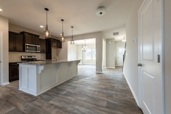 Empty modern townhouse floor showcasing a kitchen with living and dinning room ready to be moved in. Real estate, investment, renting, or house ownership concept.