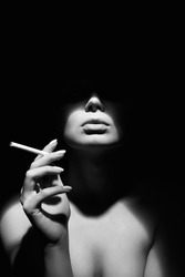 black and white portrait of Beautiful woman in a hat and with a cigarette. Retro style portrait. Lady Girl with face under Shadow