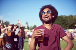 Happy African man drinking beer in festival 