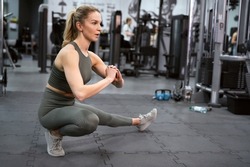 Dynamic stretching of young caucasian woman on a gym