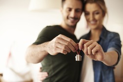 Couple holding key ring to their new house 