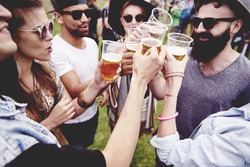 Group of friends drinking a beer at the festival 