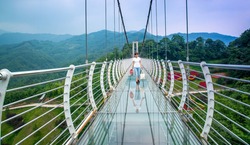 A tourist was walking on a glass bridge when the glass at his feet suddenly cracked