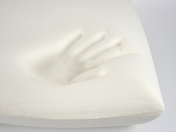 Orthopedic pillow, memory foam. Handprint on the pillow. Comfortable bedding with orthopaedic, therapeutic effect. Memory foam material.