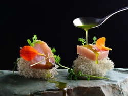 Fine dining, fresh raw ahi tuna sashimi served on sponge with herbs