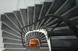 Spiral staircase with warm orange light at the end