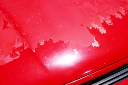 Old peeling paint on a cars bodywork.