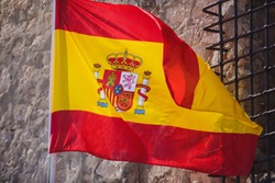 Waving flag of Spain hanging on the Kingdom of Spain institutions and administrative building in Alicante, Valencia, Spain


