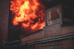Massive large blaze fire in the city, brick factory building on fire, hell major fire explosion flame blast,  with firefighters team firemen on duty, arson, burning house damage destruction 