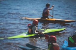 Kids learn kayaking, canoeing whitewater training in the lake river, children practicing paddling, yound kayakers in a summer camp
