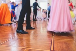 Couples dance on the historical costumed ball in historical dresses, classical ballroom dancers dancing, waltz, quadrille and polonaise in palace interiors on a wooden floor, charity event
