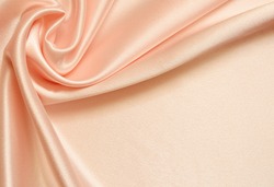 Peach silk background with drapery in the corner