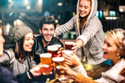 Happy people drinking beer at brewery bar out doors - Multicultural life style concept with genuine friends enjoying time together at open air restaurant patio - Vivid filter with focus on guy