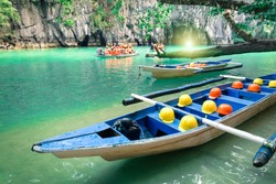 Longtail boats at cave entrance of Puerto Princesa subterranean underground river - Nature trip in Palawan exclusive Philippines destination - People with light equipment during adventurous excursion