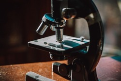 Beautiful vintage antique microscope and compass shot in dramatic sunlight with dark shadows and bright warm highlights